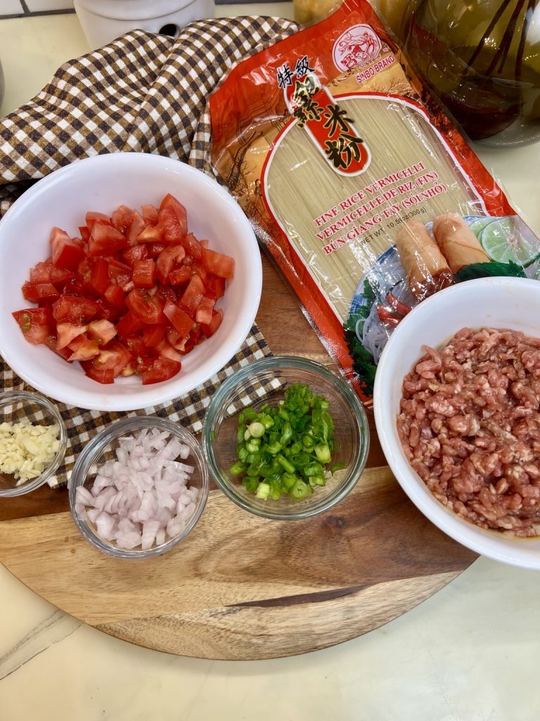 Ingredients for ground pork and tomato noodle soup, including rice vermicelli, pork, tomatoes, and seasonings