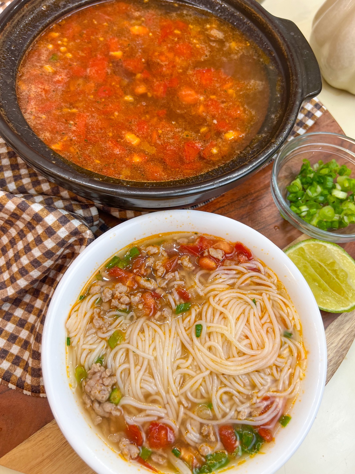 Ground pork and tomato noodle soup with rice vermicelli, tomatoes, scallions, and lime