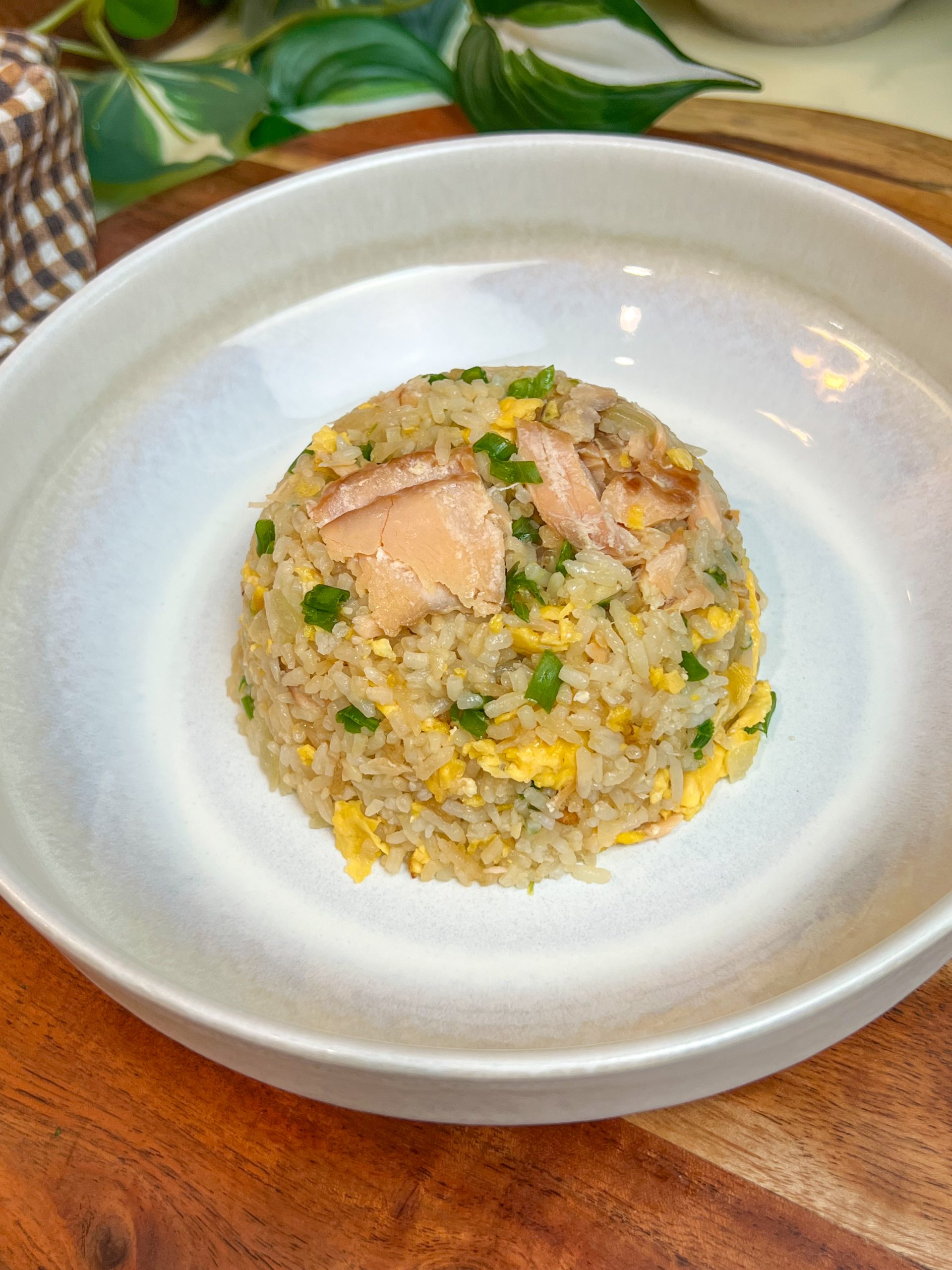 Garlic butter fried rice with smoked salmon, eggs, and scallions served in a white bowl