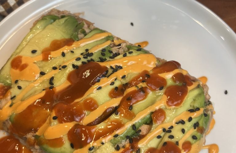 Air fryer salmon stack layered with avocado, seasoned salmon, and sushi rice, topped with spicy mayo and Sriracha.