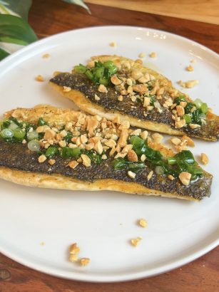 Pan-seared branzino fillets topped with scallion oil and crushed peanuts