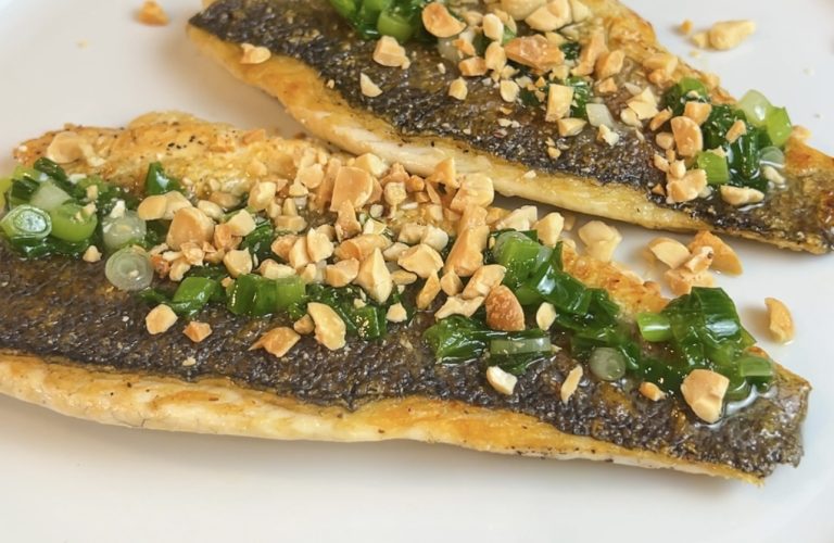 Pan-seared branzino fillets topped with scallion oil and crushed peanuts