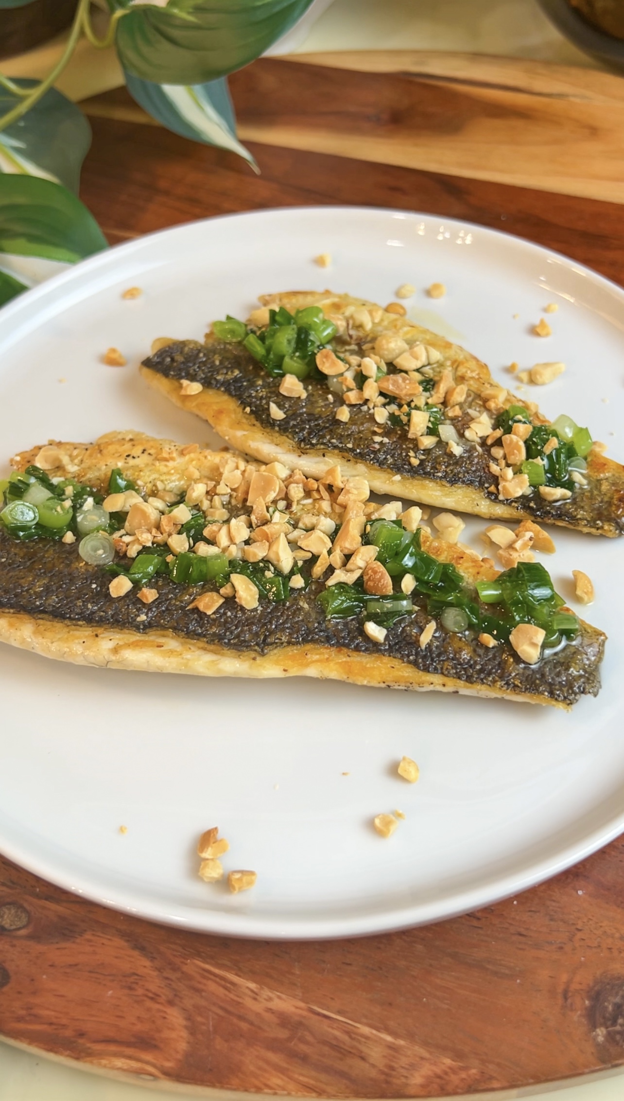 Pan-seared branzino fillets topped with scallion oil and crushed peanuts
